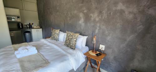 埃尔默洛Livingwaters Self-Catering Accommodation的一间卧室配有一张床和一张桌子及床头柜
