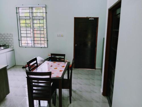 巴西富地Adilah Homestay B的一间带桌椅和窗户的用餐室