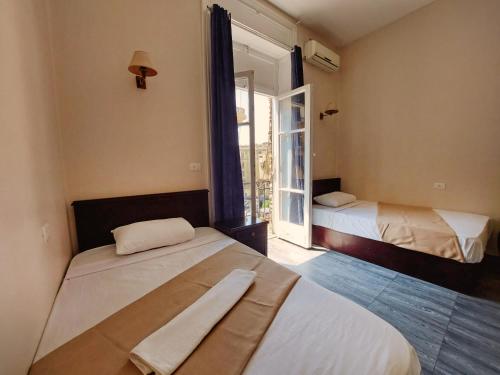 开罗Travelers House的客房设有两张床和窗户。