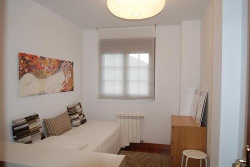 林皮亚斯Precioso apartamento junto a la ría的白色的客房设有床和窗户。