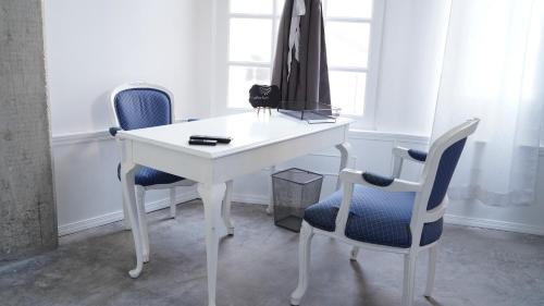 提华纳Estudio Central London Consulado的一张带两把椅子和一张桌子的白色书桌