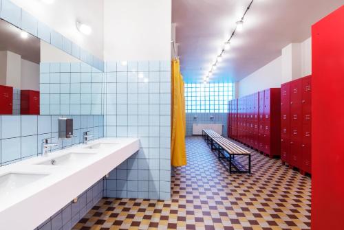第比利斯Fabrika Hostel & Suites的一间带两个盥洗盆和红色储物柜的浴室