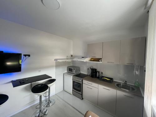 茹帕尼亚Apartman Paola - massage chair- 0-24 self check IN OUT- Županja的厨房配有白色橱柜、水槽和柜台。