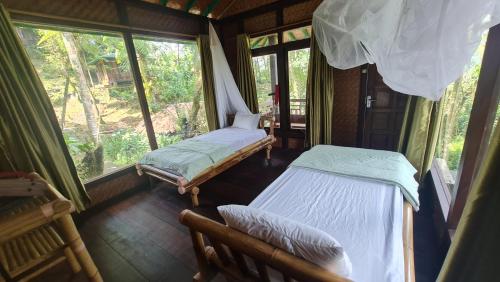 TomohonRimba eco Resort的带窗户的客房内的两张床
