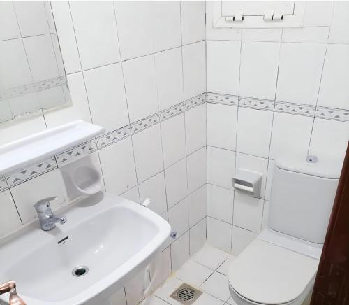 阿布扎比Corniche AD - For Males "Peaceful Bed Space"的白色的浴室设有水槽和卫生间。