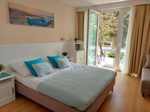 巴拉顿扎佐Szárszó Holiday Apartman的一间卧室配有一张带蓝色枕头的大床