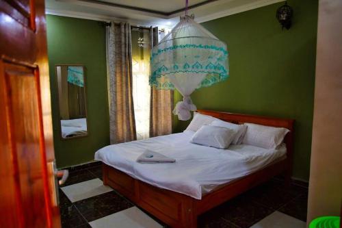 BungomaGreenstar suites的一间卧室配有一张带吊灯的床。