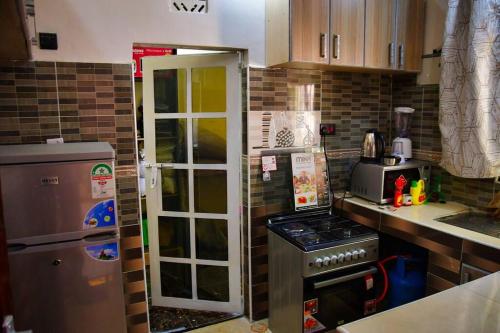 BungomaGreenstar suites的厨房配有冰箱和炉灶。