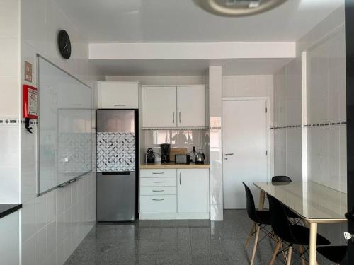 大里贝拉Conforto, espaço e localização的厨房配有白色橱柜、桌子和冰箱。