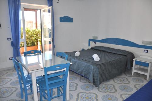 伊斯基亚Villa Myremi的卧室配有一张床和一张桌子及椅子