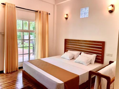 达瓦拉维Imperial Resort的一间卧室设有一张大床和一个窗户。