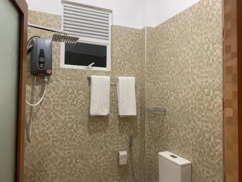 达瓦拉维Imperial Resort的带淋浴、卫生间和窗户的浴室