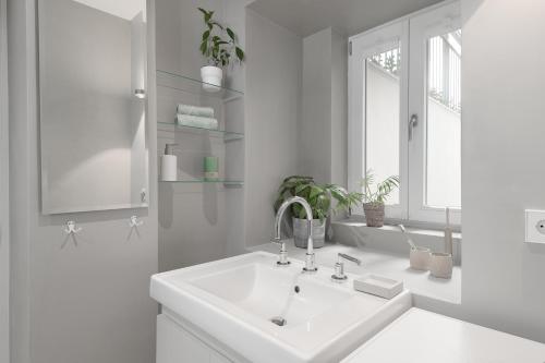 慕尼黑Exklusiv: Historisches Apartment mit Deckengewölbe的白色的浴室设有水槽和窗户。