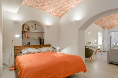 慕尼黑Exklusiv: Historisches Apartment mit Deckengewölbe的一间白色客房内的卧室,配有一张橙色的床