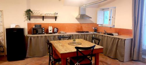马泰拉Spartivento Apartments的一间带桌子的厨房和一间带炉灶的厨房