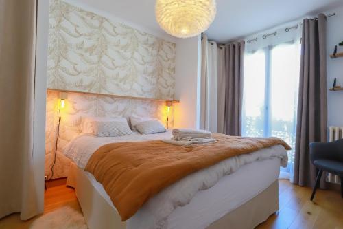 安锡Manoir 4 étoiles - 2 chambres, proche lac的一间卧室配有一张大床和一个吊灯。