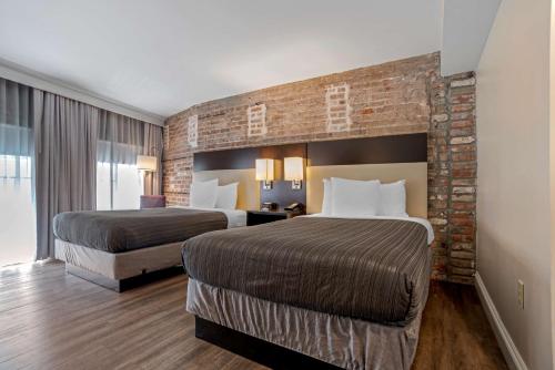 新奥尔良圣克里斯托弗贝斯特韦斯特酒店的酒店客房带两张床和砖墙