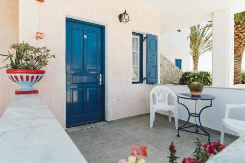 佩里萨Villa Limnes的一个带桌椅的庭院的蓝色门
