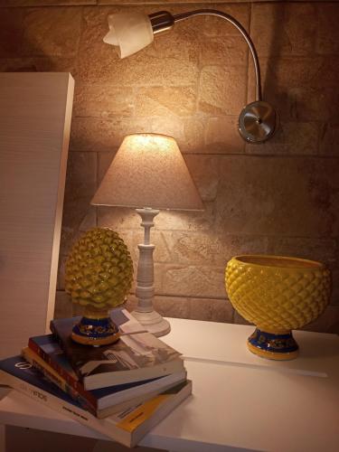 巴勒莫Zisa Home ai Cantieri Culturali的桌子上两盏灯,上面有书本和灯