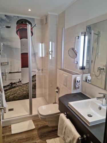 施塔德安可雅酒店的带淋浴、卫生间和盥洗盆的浴室