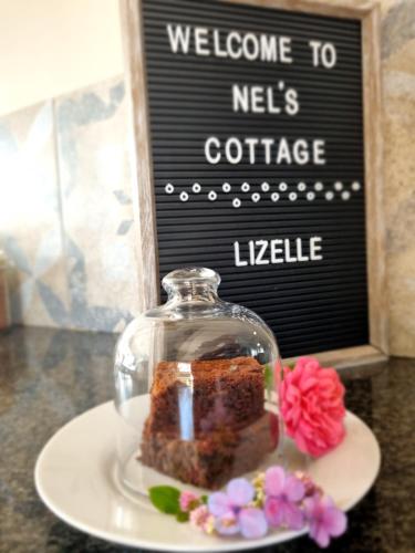 伯诺尼Nel's Cottage, a private and peaceful cottage的盘子上一块玻璃圆顶上的蛋糕
