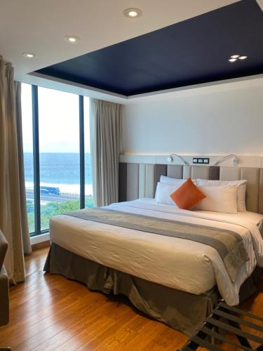 马累Beehive Premier的一间卧室设有一张蓝色天花板的大床