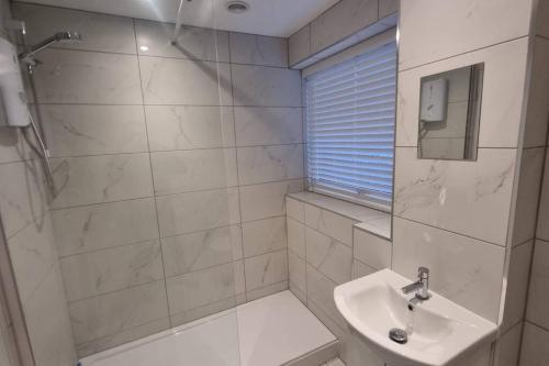 利明顿Spacious self contained flat in superb location的带淋浴和盥洗盆的浴室