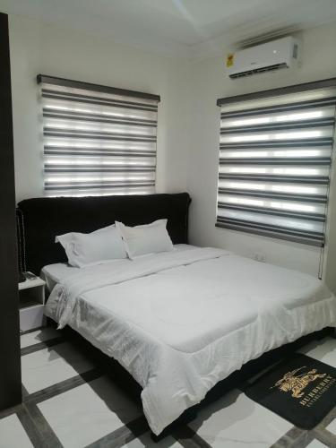 阿克拉Terra Santa Lodgings的卧室内的一张带白色床单和枕头的床