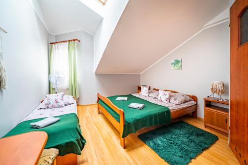 弗瓦迪斯瓦沃沃Willa Rossa的一间卧室配有两张带绿床单的床