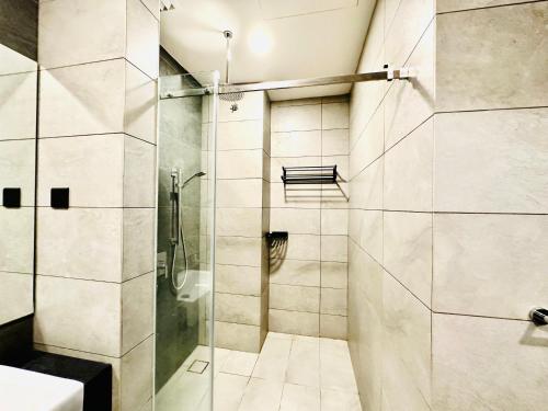 吉隆坡Millennium Suite At Opus Residence的带淋浴的浴室和玻璃门