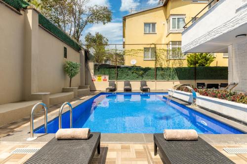 伊斯坦布尔Baymari Suites Design Florya的一座游泳池,旁边设有两张躺椅