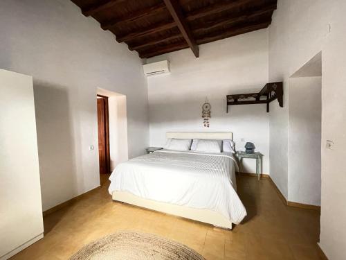 圣何塞德萨塔莱阿Finca Can Toni den Real的卧室设有白色的床和木制天花板。