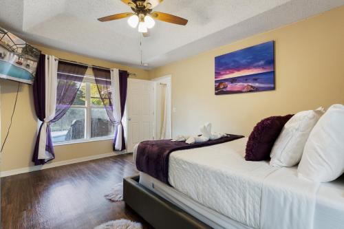 奥兰多Master Guest Suite with Pool and Private Entrance Minutes to Parks的一间卧室配有一张带吊扇和窗户的床。