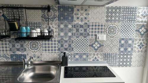 利沃诺ACCADEMIA Rooms的厨房设有水槽和瓷砖墙