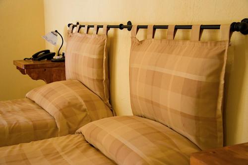 切萨纳·都灵尼斯HOTEL LA GINESTRA的卧室配有2个枕头