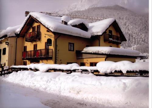 切萨纳·都灵尼斯HOTEL LA GINESTRA的前面的雪覆盖的房子