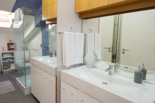 洛萨Lousã Varandas House的白色的浴室设有水槽和镜子