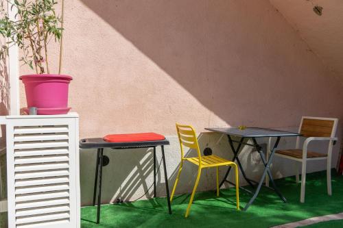 马赛LE PETIT NID DES CHUTES LAVIES的绿地客房内的两张桌子和椅子