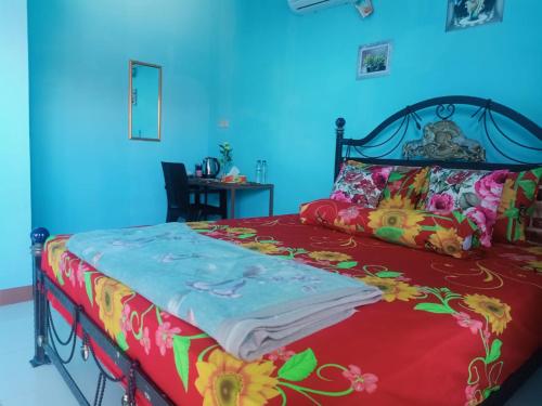 纳闽巴霍Cowang Dereng Home Stay的一间卧室配有一张带红色多彩毯子的床