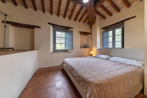 San BiagioMaison Uccellina的一间卧室设有一张大床和两个窗户。