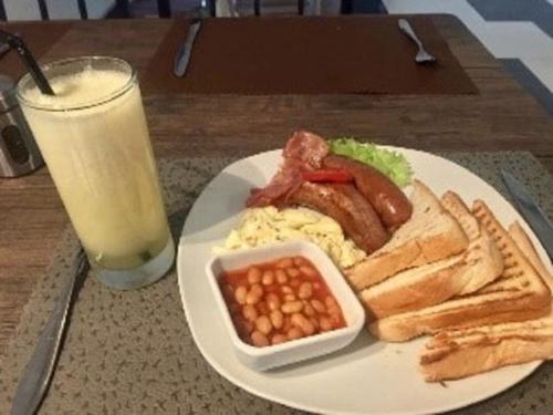 AfwerasiEl-King Home Lodge的包括鸡蛋培根豆和一杯牛奶的早餐食品