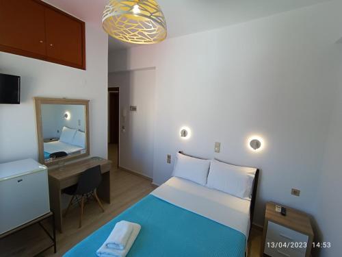 干尼亚伊梅洛斯酒店的一间卧室配有一张床、一张书桌和一面镜子