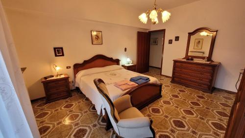 米拉佐La casa di nonna Carmelina的一间卧室配有一张床、一把椅子和镜子