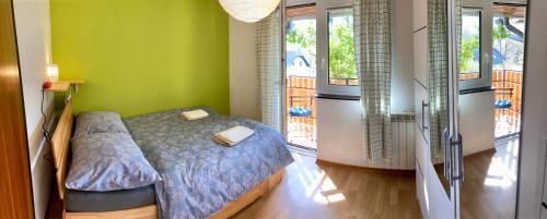 博维茨Holiday Home Kristi的一间卧室设有床铺、绿色的墙壁和窗户