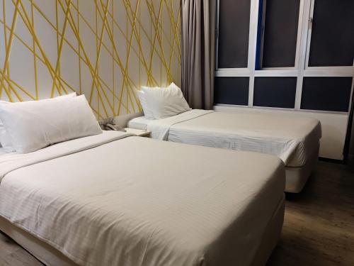 云顶高原Comfy Room In Genting Highlands的配有白色床单的酒店客房内的两张床