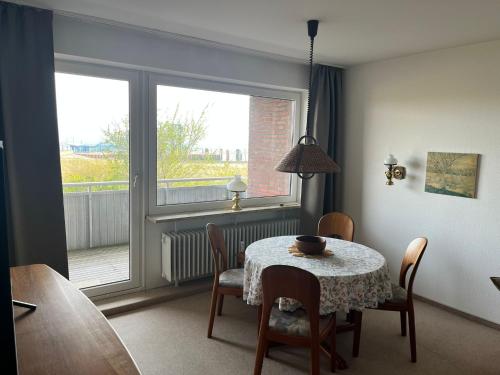 维滕Haus Seelöwe Wohnung 1的一间带桌椅和窗户的用餐室