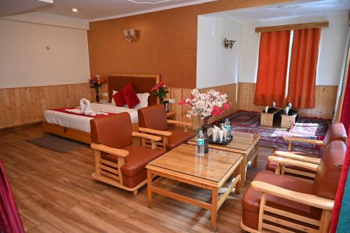 马拉里Hotel Seven Hills Manali的酒店客房带一张床、一张桌子和椅子