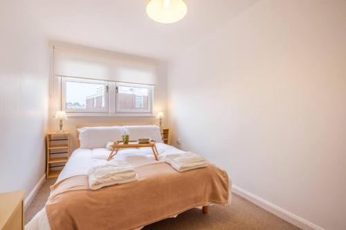 拉纳克Station Apartment 1 bed- Lanark的一间卧室配有一张桌子和一张床铺