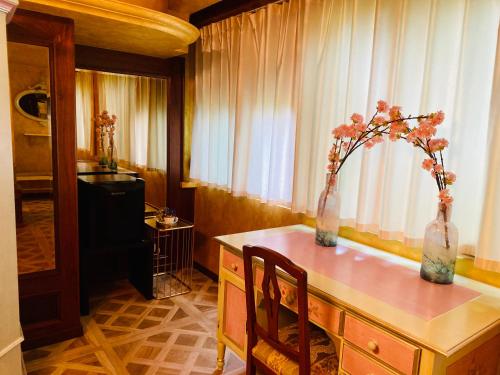 乌迪内奥勒杜伊帕尔梅酒店的一间房间,桌子上放着两瓶花花
