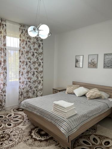 乔尔蓬阿塔Коттедж на берегу Иссык-Куля的一间卧室配有一张大床和一个吊灯。